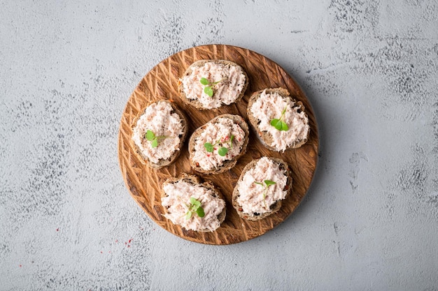 Bruschetta with tuna pate fish rillettes on concrete background top view