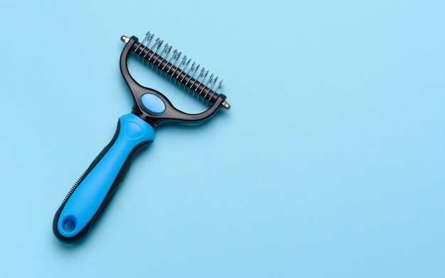 Brush for grooming cats and dogs on a blue background top view