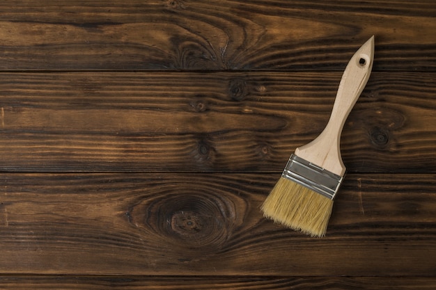 Photo brush with large bristles on a tinted wooden wall. the rendering of wood.