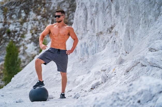 Brutal strong bodybuilder posing outdoor.