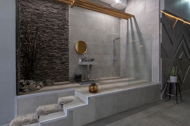 Brutal ultra trendy interior design of an openplan apartment with an open shower decorated with gray stone