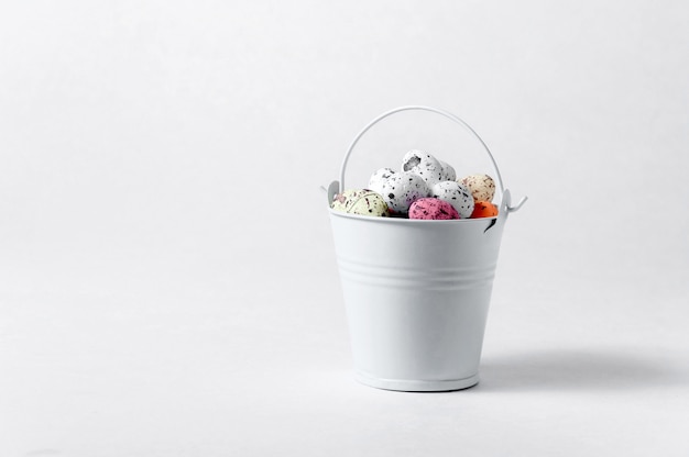 Bucket with Easter Eggs on White Background. Creative  . Minimalism Concept. Copy Space For Your Text.