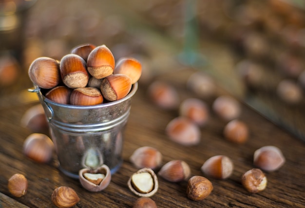 Bucket with hazelnut on a wooden background