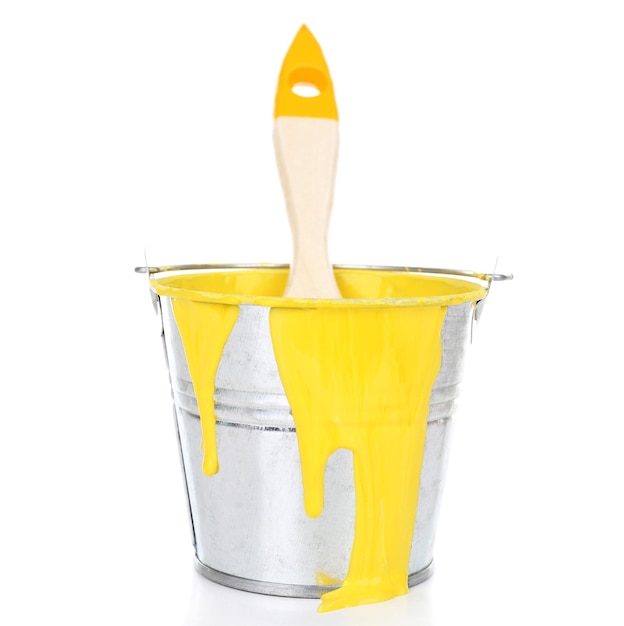 Bucket of yellow paint with brush isolated on white