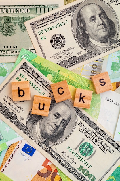 BUCKS inscription on wooden cubes on the texture of us dollars and euro banknotes