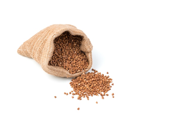 Buckwheat is poured out of a linen bag on the table.