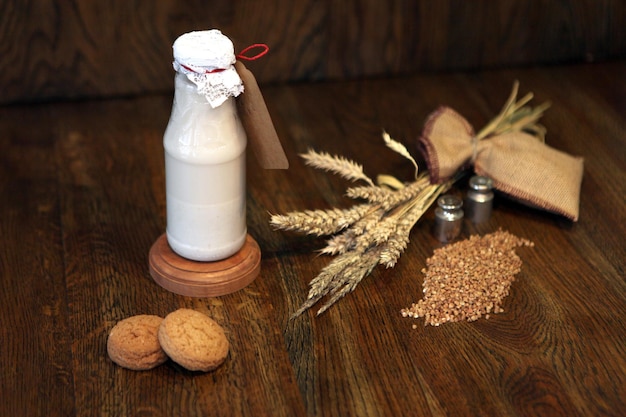 Buckwheat milk in a bottle and buckwheat in a glass jar on a light background. Delicious Botteled milk product for vegans. Healthy organic nutrition concept