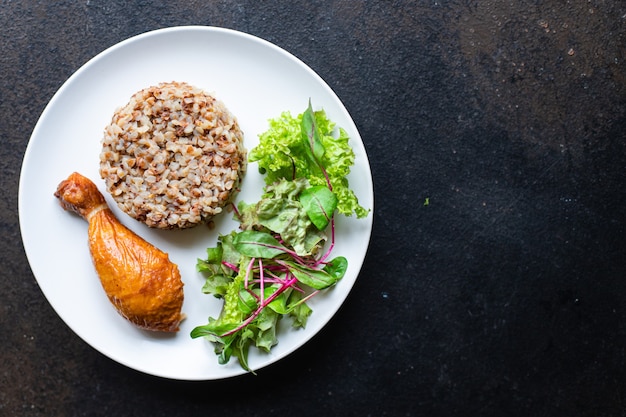 Buckwheat porridge with chicken leg salad leaves green petals lettuce