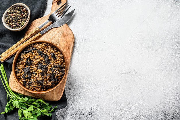 Buckwheat porridge with mushrooms in a wooden pot. . Top view. Copy space