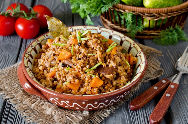 Buckwheat with meat and vegetables on wooden table rustic style