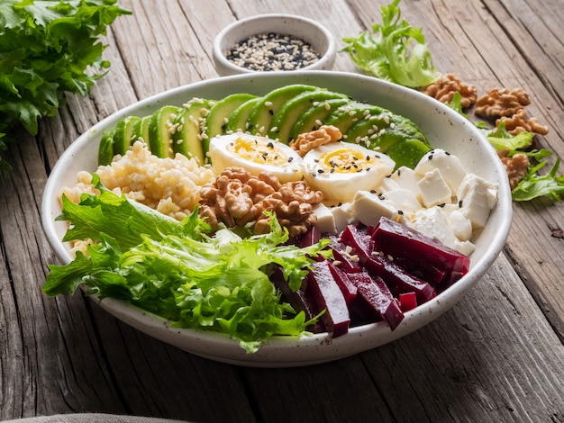 Buddha bowl, balanced food, vegetarian menu. Old wooden dark table, side view. 