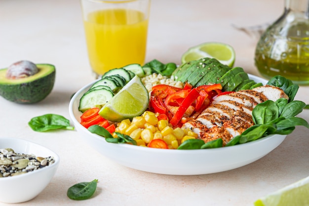 Buddha bowl with bulgur, grilled chicken, vegetables, avocado and spinach. Healthy food concept.