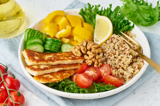 Buddha bowl with halloumi, quinoa, salad lettuce, vegeterian food, white , top view