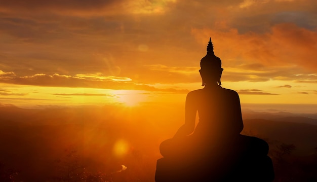 Buddha silhouette on golden sunset background beliefs of Buddhism