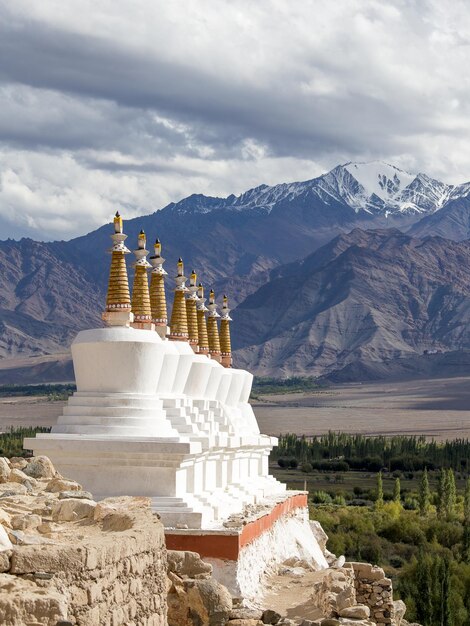 Buddhist chortens stupa and Himalayas mountains in the background near Shey Palace in Ladakh India