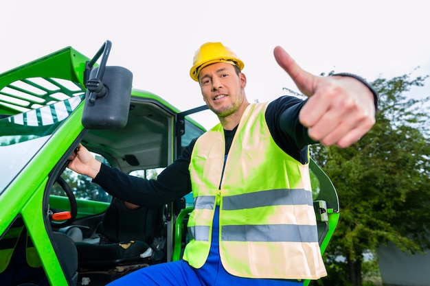 Builder in front of  construction machinery