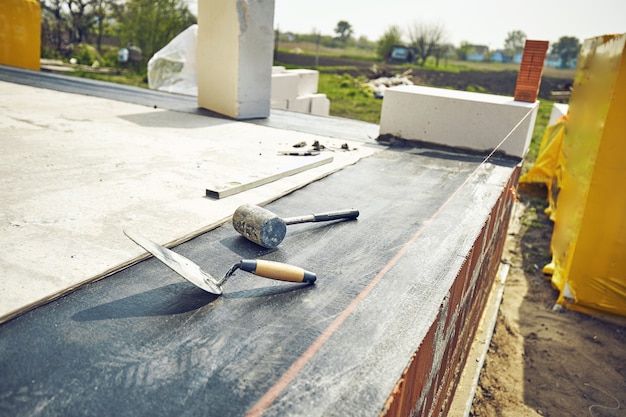 Builder lays aerated concrete block at a construction site