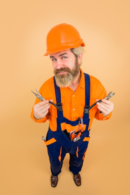 Builder man pliers worker holds pliers industrial worker with pliers repair industry technology