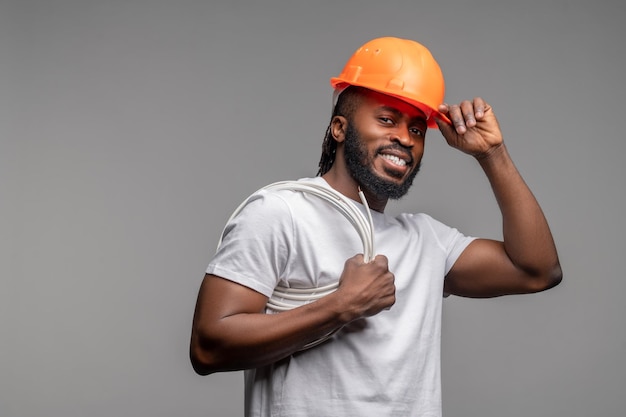 Builder with a wrapped power cable over his shoulder