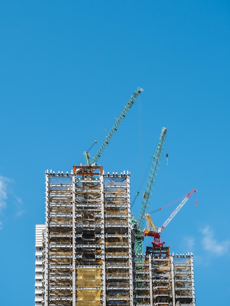 Building under construction, cranes and high-rise building