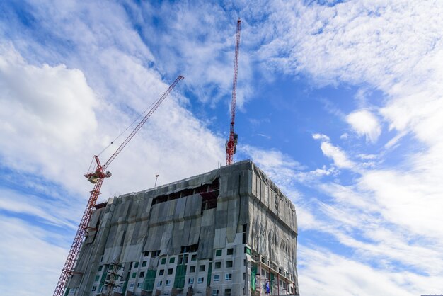 Building and crane is in under construction with cloud and blue sky