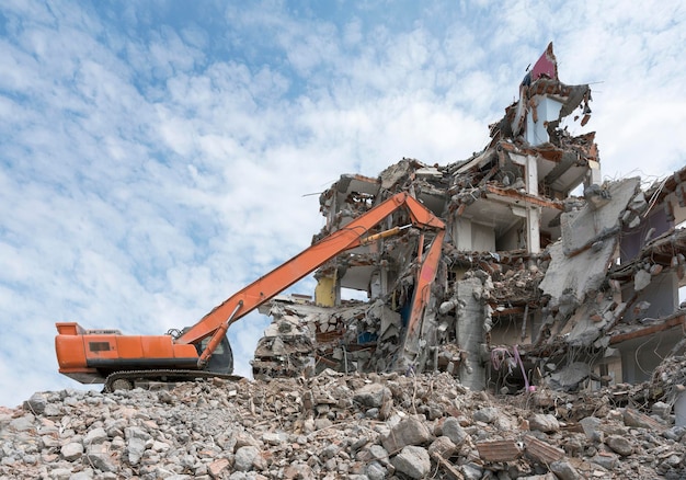 Building House Demolition site Excavator with hydraulic crasher machine and yellow container