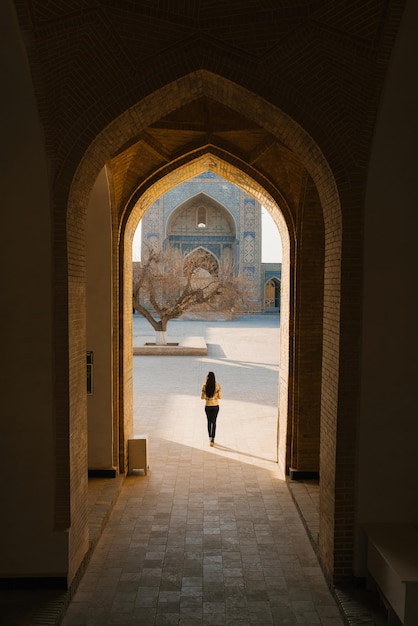 Bukhara Uzbekistan March 2022 The girl stands with her back in the doorway of the Kalyan Minaret