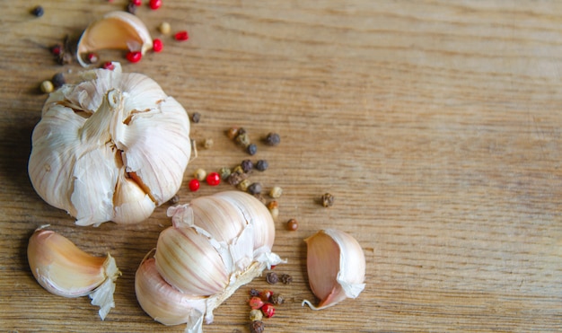 Bulbs of organic garlic and garlic cloves on natural wooden table