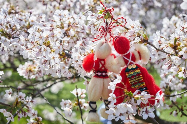 Photo bulgarian traditional spring decor martenitsa on the cherry blossom tree baba marta holiday