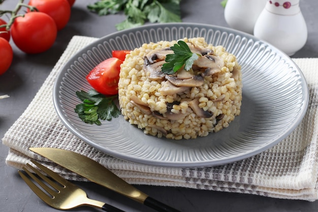 Bulgur garnish with champignons on a gray plate