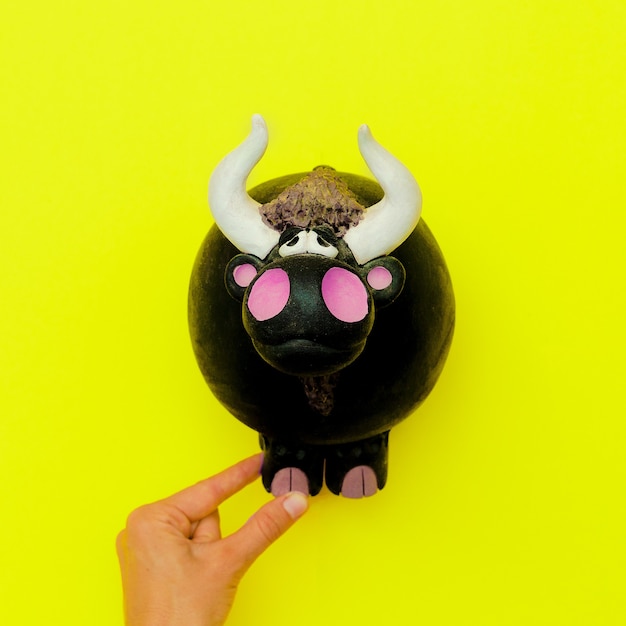 Photo bull souvenir toy on a yellow background. minimal flat lay art