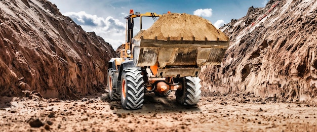 Photo bulldozer or loader at a construction site in a quarry transporting sand powerful wheel loader or bulldozer with a large bucket at a construction site construction equipment for earthworks