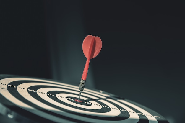 Bullseye has dart arrow throw hitting the center of a shooting target for business targeting.