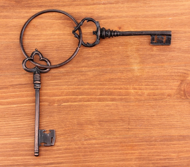 A bunch of antique keys on wooden background