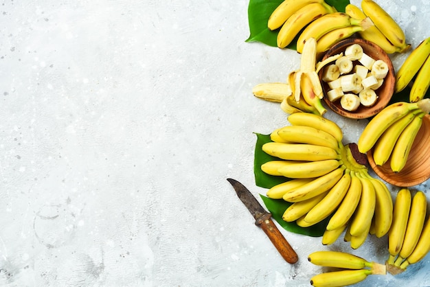 A bunch of bananas and a sliced banana baby on a table delicious natural On a stone background Free copy space Top view