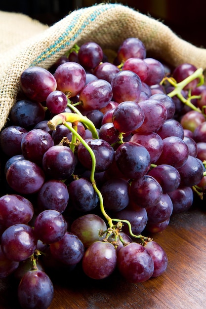 Bunch black grapes on wooden background