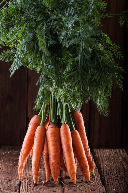 Bunch of carrots on rustic table. Vegetables harvest.