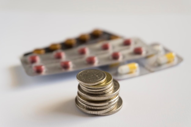 A bunch of coins and medicine on the background The concept of expensive drugs