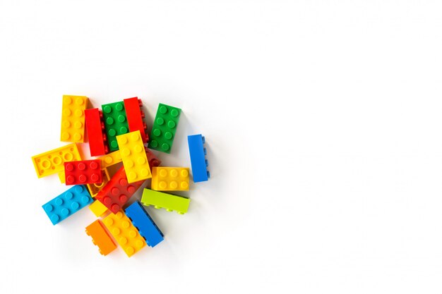 Photo bunch of colorful plastick constructor cubes on white. popular toys. copyspace