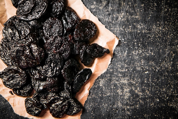 A bunch of delicious prunes on paper on the table