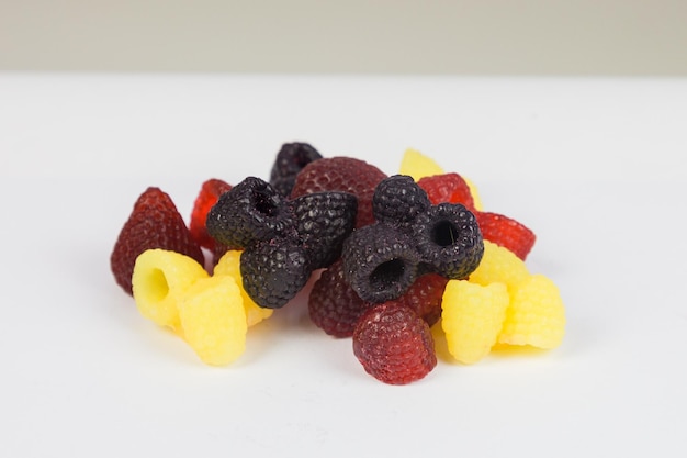 A bunch of exclusive handmade soap in the form of bright raspberries and blackberries on a white background