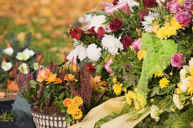 Bunch of flowers and flower pot with Erica flower  on grave