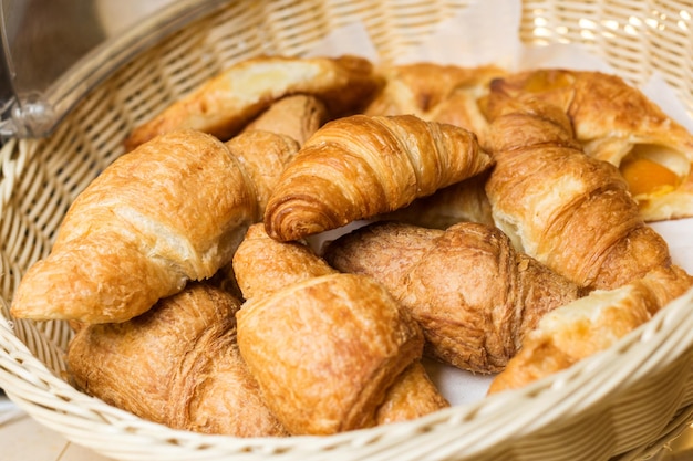 Bunch of fresh croissants in a straw basket