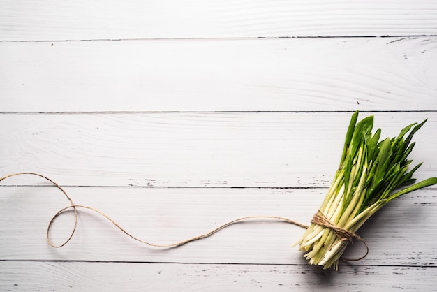 A bunch of fresh ecofriendly and healthy greens on a white wooden background