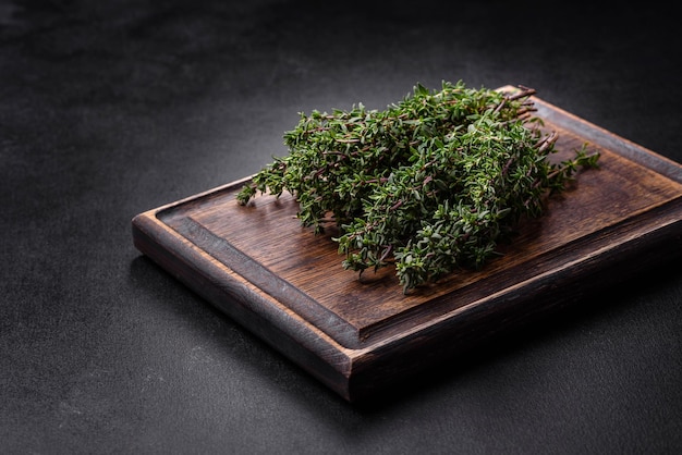 Bunch of fresh picked thyme on a dark concrete background Spices and herbs for cooking meat