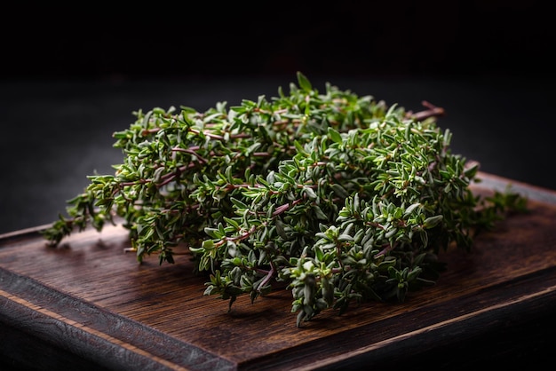 Bunch of fresh picked thyme on a dark concrete background Spices and herbs for cooking meat