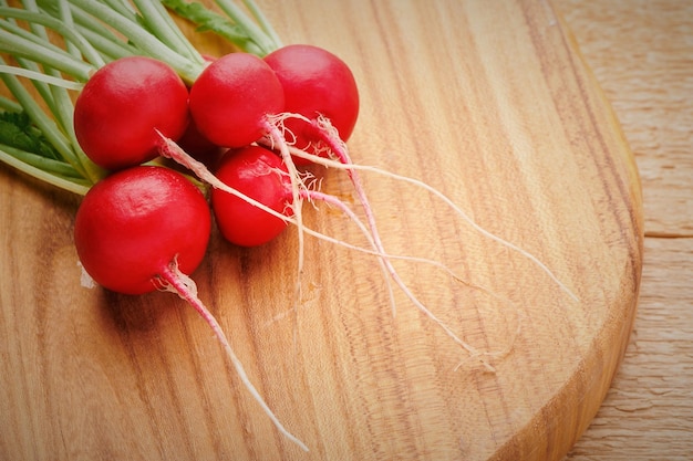 Bunch of fresh radish with leaves on cutting board Vitamin vegetables Fresh garden harvest Close up view with shallow DOF