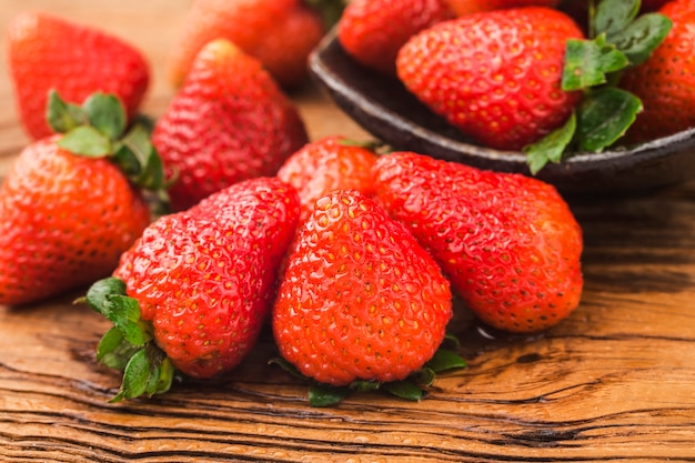 Bunch of fresh strawberries on wooden board background