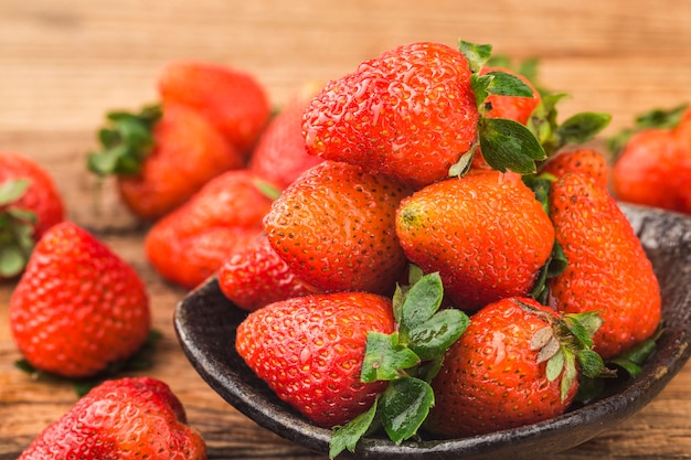 Bunch of fresh strawberries on wooden board background