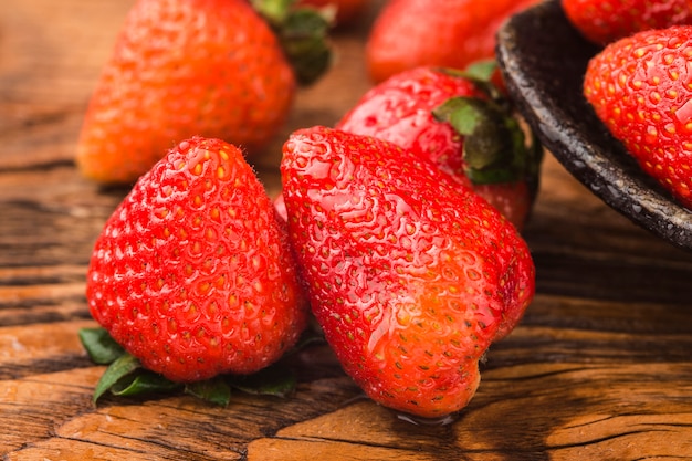 Bunch of fresh strawberries on wooden board background